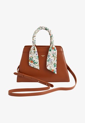 Brązowa skórzana torebka z długim paskiem, krótkimi uchwytami owiniętymi białym kwiecistym szalem oraz małym złotym emblematem pszczoły z przodu.