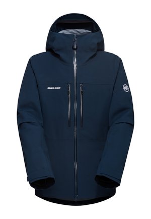 Mörkblå utomhusjacka med huva, frontdragkedja, två bröstfickor och Mammut-logotyp. Tillverkad av slitstarkt material med en slät textur.