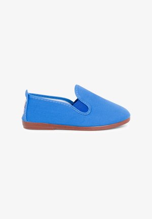 Blue canvas slip-on shoe with a round toe, elastic side accents, and a brown rubber sole. Features textured fabric and a simple design.