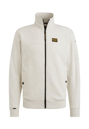 Veste gris clair avec un motif texturé en forme de bulles. Elle présente un col haut, une fermeture éclair à l'avant, des poches latérales et un patch logo sur la poitrine.