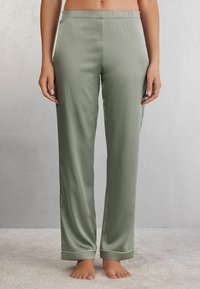 Groene satijnen pyjamabroek met een elastische tailleband en contrasterende manchetten, met een recht model en een gladde textuur.