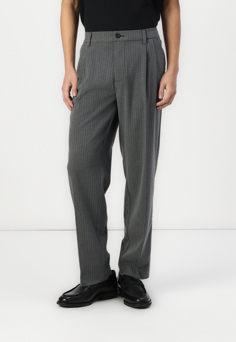 Gray pinstriped trousers with a relaxed fit, featuring a single front pleat, belt loops, and a button closure, paired with black shoes.
