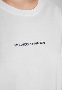 White cotton t-shirt featuring a round neckline and short sleeves, with the text "MSHCHOPENHAGEN" in bold black lettering on the front.