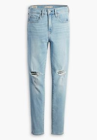 Vaqueros de mezclilla azul claro con un corte ajustado, que presentan rotos envejecidos en las rodillas, diseño de cinco bolsillos y detalles cosidos en la pretina.