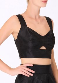 Crop top noir en satin, doté de larges bretelles, d'un design plissé à l'avant et d'un détail découpé sous la poitrine. Texture lisse.