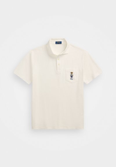 Korte ermede, elfenbensfarget polo-shirt laget av bomull, med plastrong med tre knapper, brystlomme og brodert logo av en bjørn.
