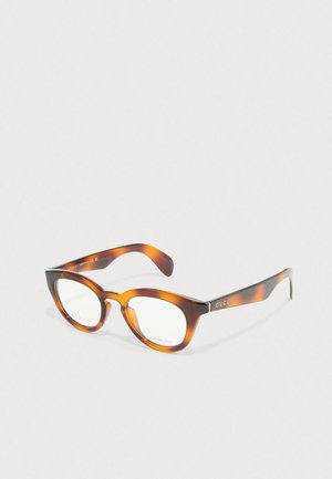 Brązowe okulary w kształcie kota z tortoiseshell, z przezroczystymi soczewkami i logo "GUCCI" na zausznicach. Gładka plastykowa tekstura.