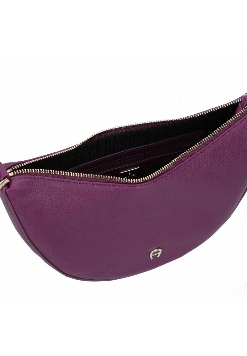 Paarse leren schoudertas met een gebogen vorm, ritssluiting en zilverkleurige hardware. Het interieur heeft een contrasterende, gedessineerde stofvoering.