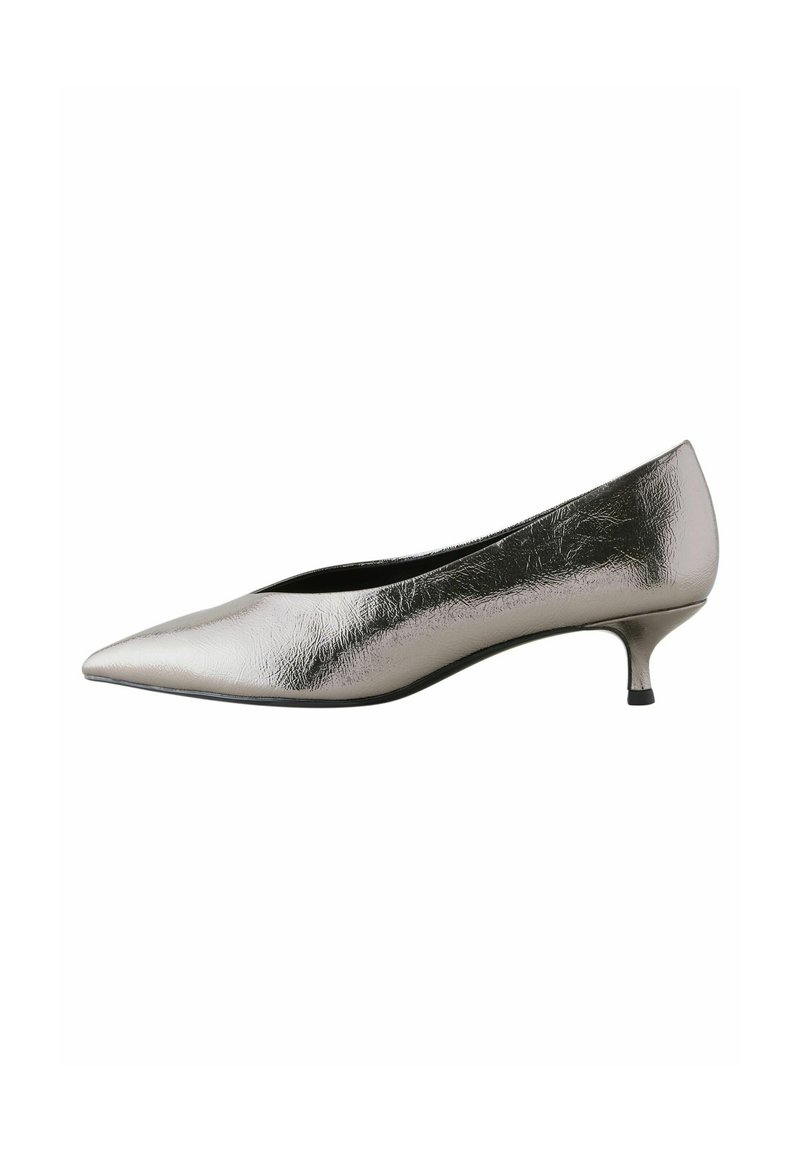 Zapato de tacón alto plateado metálico con punta afilada y un tacón bajo tipo kitten. Presenta una textura suave y un diseño elegante.