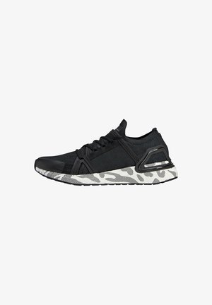 Baskets de sport noires avec dessus en maille, lacets noirs et semelle blanche présentant des motifs abstraits noirs et gris, vues de côté.