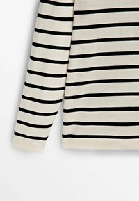 Gestreiftes Langarmoberteil in Creme und Schwarz, mit gleichmäßigen horizontalen Streifen, weicher Textur und tailliertem Design.