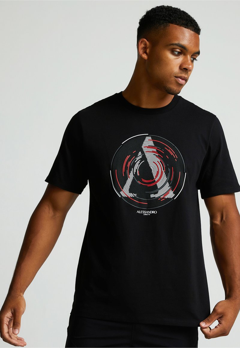 Čierne bavlnené tričko s kruhovým grafickým dizajnom v červenej, bielej a čiernej farbe, obsahujúce sústredné línie a názov značky "Alessandro Zmeti."