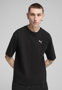 Černé bavlněné tričko s krátkými ruk�ávy a kulatým výstřihem. Na levé hrudi je bílé logo Puma. Hladká textura, volný střih.