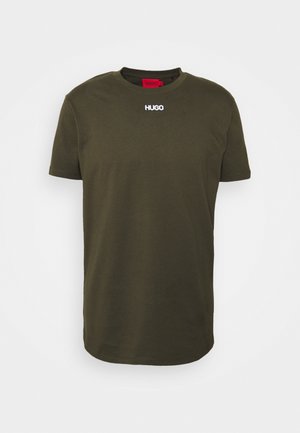 Oliwkowa bawełniana koszulka z krótkim rękawem, okrągłym dekoltem i białym logo "HUGO" na piersi. Gładka tekstura i standardowy krój.