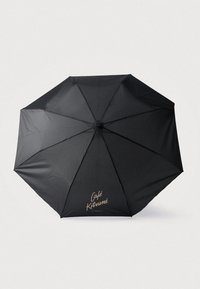 Čierny dáždnik s elegantným dizajnom z ôsmich panelov. Má vytlačené "Café Kitsuné" v zlatej farbe na jednom paneli. Hladký povrch, ľahký materiál.