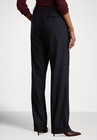 Σκούρο μπλε παντελόνι με λεπτές ρίγες, ψηλή μέση, στενά πόδια, πλαϊνές τσέπες και πίσω τσέπη με κουμπί. Λείο, ελαφρύ ύφασμα.