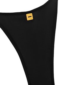 Bas de bikini noir en tissu lisse, avec un design à taille haute et une petite étiquette dorée portant l'inscription "Manila Grace".