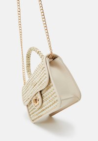 Borsa beige con una texture intrecciata, tracolla in catena dorata e chiusura a patta con un dettaglio hardware decorativo in oro.