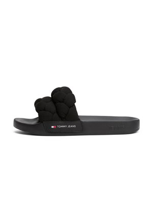 Czarny sandał typu slide Tommy Jeans z wyściełanym, plecionym paskiem i logo po boku podeszwy, płaska podeszwa, widok z boku na białym tle.