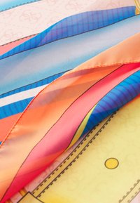 Foulard di seta multicolore con strisce vivaci nei toni dell'arancione, blu e rosa, caratterizzato da una texture morbida e motivi contornati.