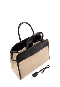 Canvas and leather handbag with a beige body and black trim. Features double handles, gold hardware, and a detachable strap.