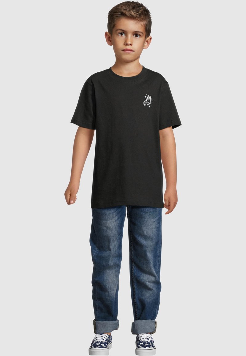 Black cotton t-shirt with a butterfly graphic on the chest, paired with blue denim jeans, featuring rolled cuffs and casual sneakers.