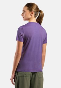 Purple short-sleeve t-shirt made of soft fabric, featuring a classic crew neck and a relaxed fit, paired with green cargo pants.