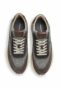 Sneakers con tomaia grigia intrecciata, dettagli in suede marrone, suola beige e lacci avorio. Include un logo su una patch in pelle.