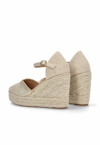 Cuñas de esparto en color beige con textura trenzada, correa en el tobillo ajustable, puntera afilada y un grueso tacón envuelto en yute.