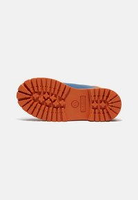 Suola delle scarpe da esterno, in gomma arancione con scanalature profonde per una migliore trazione, caratterizzata da un'impronta del logo e una superficie texturizzata per la durata.