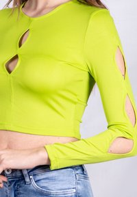 Top corto a coste verde lime con scollatura rotonda, apertura a forma di chiave e dettagli delle maniche aperte, caratterizzato da una silhouette aderente.