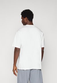 Hvid bomulds T-shirt med rund hals og korte ærmer, med en lige pasform og uden synlige designs eller mønstre.