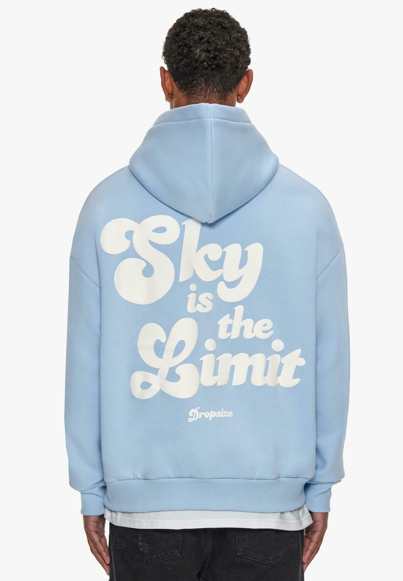 Light blue hoodie featuring a large white printed text "Sky is the Limit" on the back. It has a drawstring hood and ribbed cuffs.