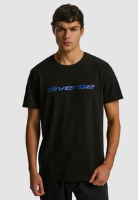 Czarny bawełniany t-shirt z okrągłym dekoltem, z niebieskim nadrukiem graficznym "diverse" na piersi i krótkimi rękawami.