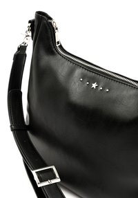 Borsa a spalla in pelle nera con chiusura zip, caratterizzata da un accento a forma di stella e tre borchie metalliche. Include una tracolla piatta con una fibbia argentata.