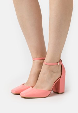 Scarpe con tacco alto in vernice rosa, con punta affusolata, tacco a blocco spesso e cinturino alla caviglia con fibbia in tono oro.