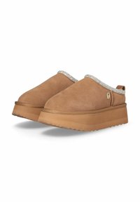 Scarpe slip-on in camoscio beige con suola in gomma texturizzata, dotate di una decorazione in strass attorno all'apertura e un piccolo logo sul lato.