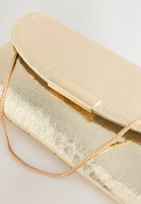 Metallist kuldse värvitooni käekott tekstuurse viimistlusega, millel on kaardus klapp ja kuldse metalli detail. Sisaldab põimitud ketist rihma.