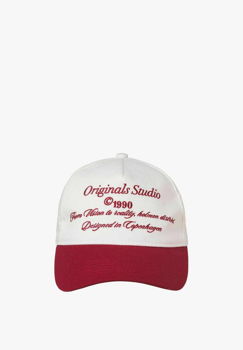 Casquette blanche avec une visière incurvée rouge et du texte brodé en rouge. Porte les inscriptions : « Originals Studio », « © 1990 » et « Conçu à Copenhague ».