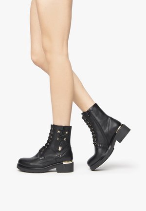 Black leather ankle boots with a round toe, gold hardware accents, lace-up front, and side zipper. Chunky heel for stability.