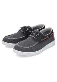 Scarpe in stoffa nera con suole in gomma bianca, caratterizzate da una superficie testurizzata, lacci grigi e piccoli dettagli in pelle marrone sui lati.