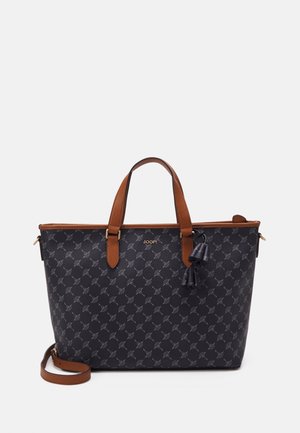 Černá vzorovaná taška na rameno s hnědými koženými rukávy, ozdobou střapce a zipovým uzávěrem. Má pevný tvar a ozdobu s logem.