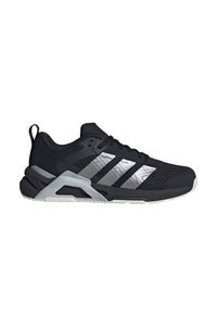 Chaussure de sport noire avec une tige en mesh, trois bandes argentées, une semelle rembourrée et un accent distinctif en forme de talon angulaire.