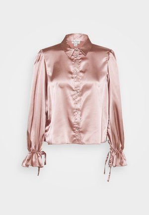 Blouse longue en satin rose à manches longues avec col, boutons sur le devant, épaules bouffantes et poignets volantés attachés avec des rubans.