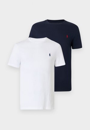 Duas t-shirts com gola redonda, uma branca e outra azul-marinho, feitas de algodão. Ambas apresentam um pequeno logótipo no peito em cores contrastantes.