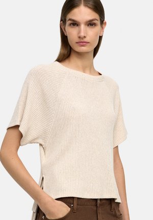 Beżowy top z prążkowanego dzianiny z krótkimi rękawami i bocznymi rozcięciami; ma szeroki dekolt i luźny krój, wykonany z miękkiego, fakturowanego materiału.