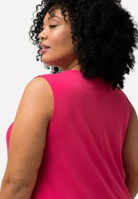 Fuchsia mouwloze top met een gladde textuur en een ronde halslijn, met zichtbare naden en een relaxte pasvorm voor comfort.
