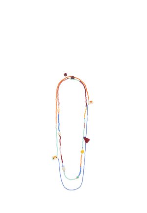 Długi, wielokolorowy naszyjnik z koralików z różnymi małymi zawieszkami i czerwonym chwostem na białym tle.