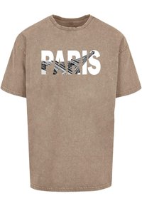 Brun, falmet bomulds T-shirt med korte ærmer og rund halsudskæring. Har ordet "PARIS" i fede, hvide bogstaver med et grafisk design indeni.