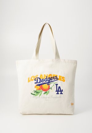 Biała torba na ramię z tekstem "Los Angeles Dodgers", ilustracją pomarańczy i niebieskim logo "LA" na przednim środku.